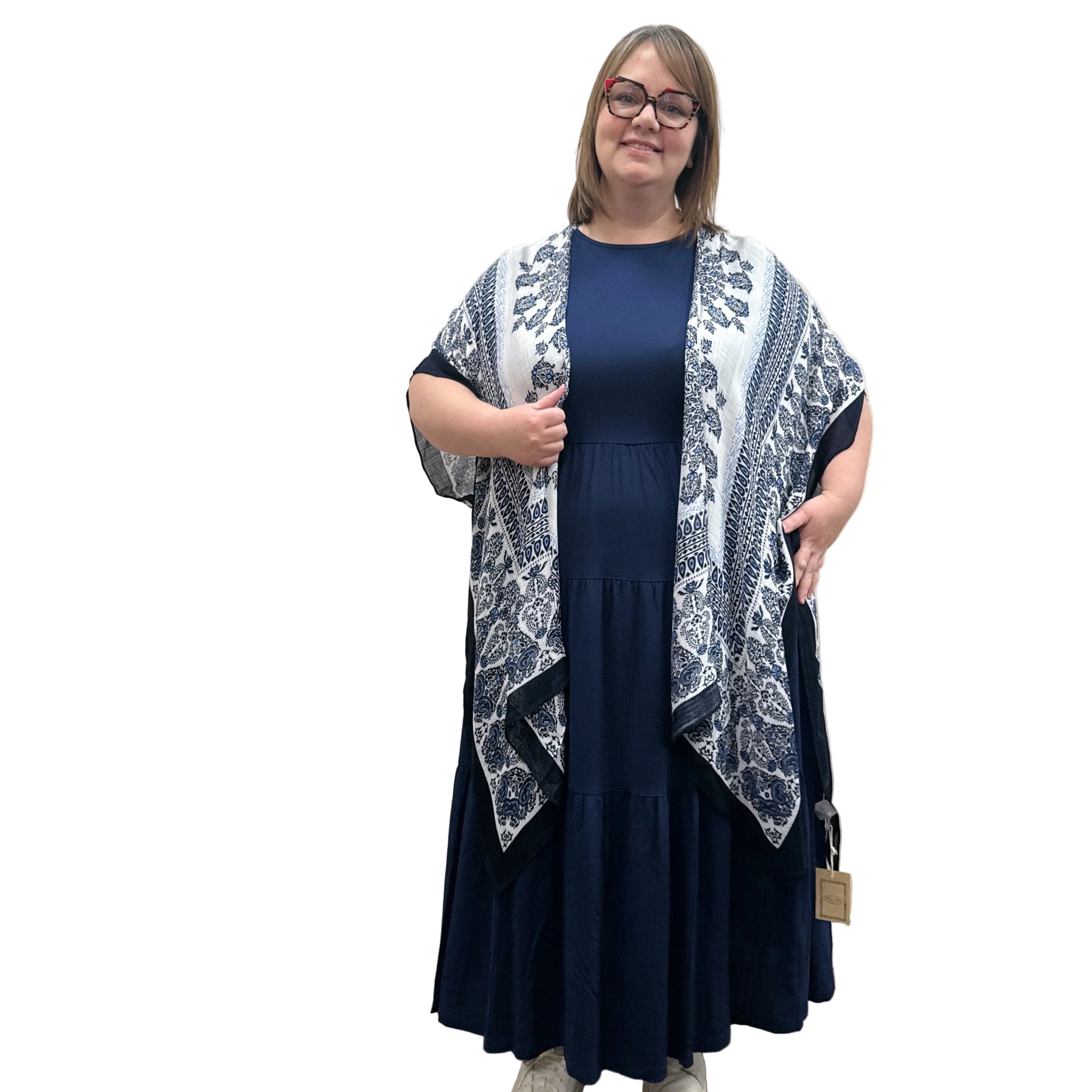 Woman wearing a blue and white patterned Blue Sky Darcy kimono over a dark dress on a white background