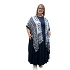 Woman wearing a blue and white patterned Blue Sky Darcy kimono over a dark dress on a white background