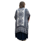 Woman wearing a blue and white patterned Blue Sky Darcy kimono over a dark dress on a white background