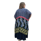 Woman wearing a navy dress with a floral Blue Sky Darcy kimono on a white background. 