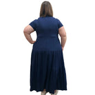 Woman wearing a dark blue Blue Sky Erin dress against a white background