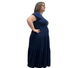 Woman wearing a dark blue Blue Sky Erin dress against a white background