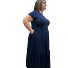 Woman wearing a dark blue Blue Sky Erin dress against a white background