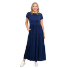Woman wearing a dark blue Blue Sky Erin dress against a white background