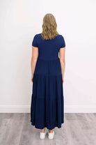 Woman wearing a dark blue Blue Sky Erin dress against a white background