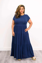 Woman wearing a dark blue Blue Sky Erin dress against a white background