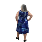 Woman wearing a blue patterned Blue Sky Sara Dress on white background. 
