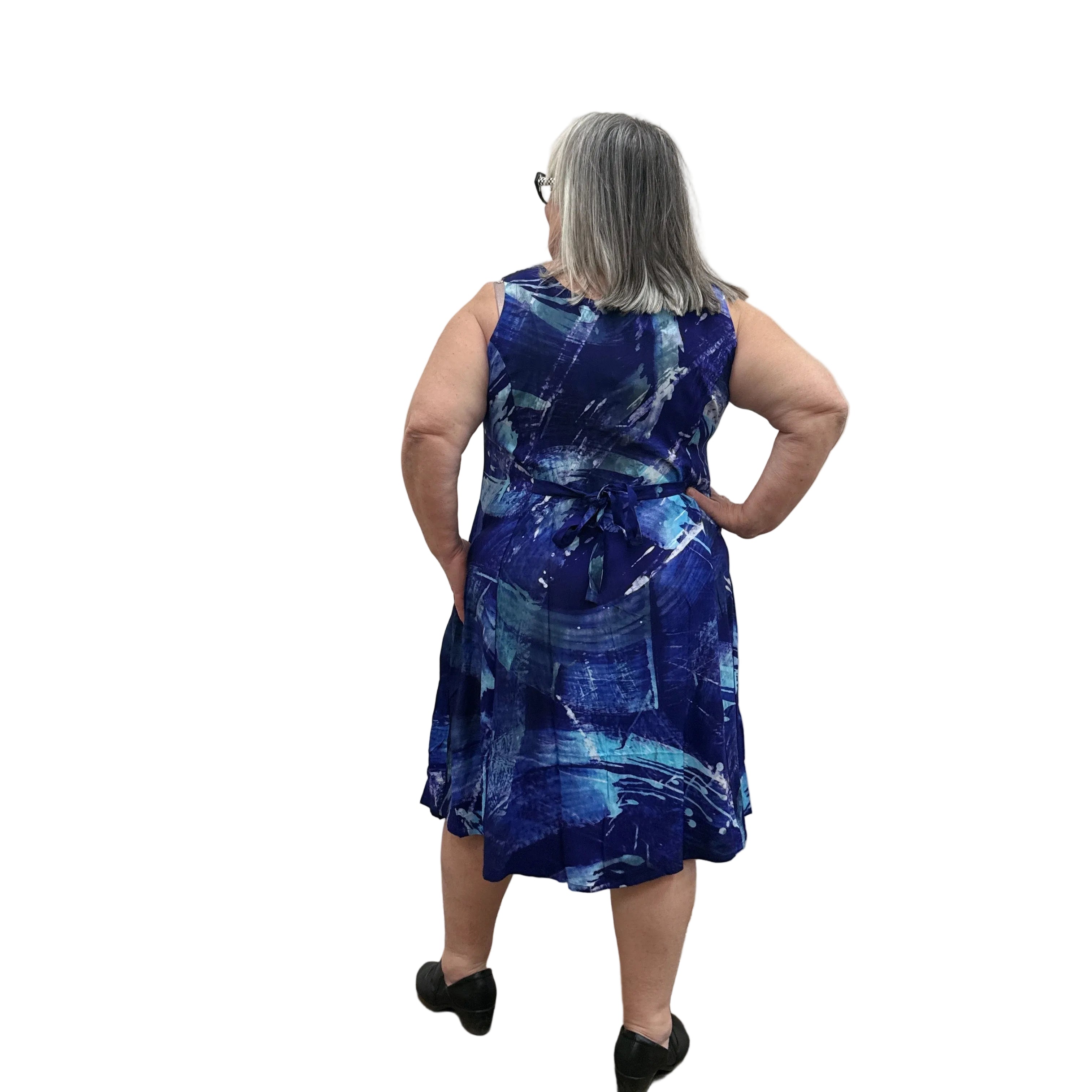 Woman wearing a blue patterned Blue Sky Sara Dress on white background. 