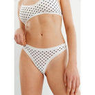 The Micro Thong panty in Dots pattern, white panty with black polka dots, shown on a model front view. 