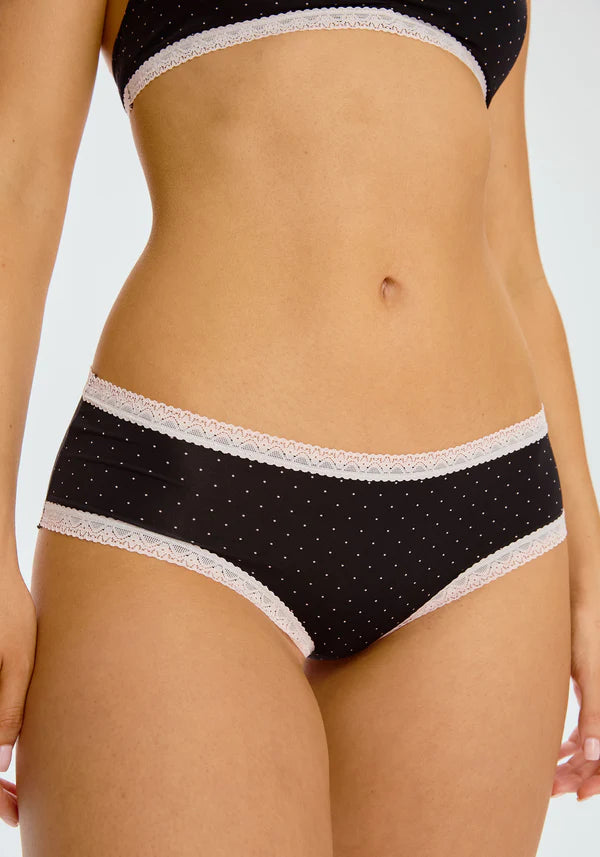 This image features the "Micro Hipster" panty from Blush, showcasing its delicate and chic design. The panty is low-rise with cheeky coverage, adorned with a subtle polka dot pattern and elegant lace trim.