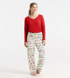 Woman wearing a red top and patterned pajama pants on a white background