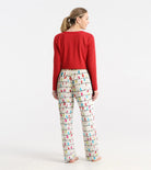 Woman wearing a red top and colorful patterned pants on a white background