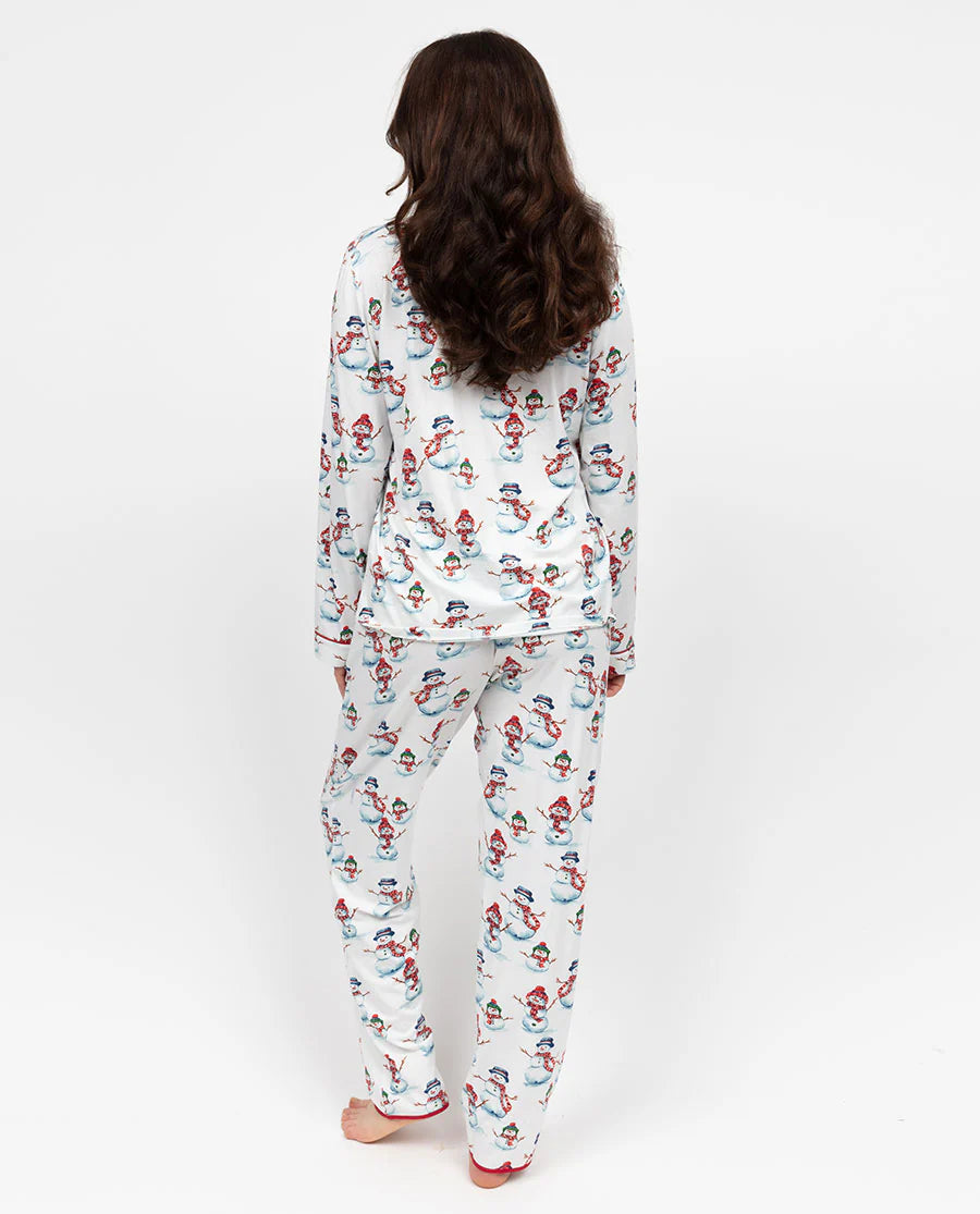 Person wearing a festive pajama set with snowmen and Christmas trees on a white background