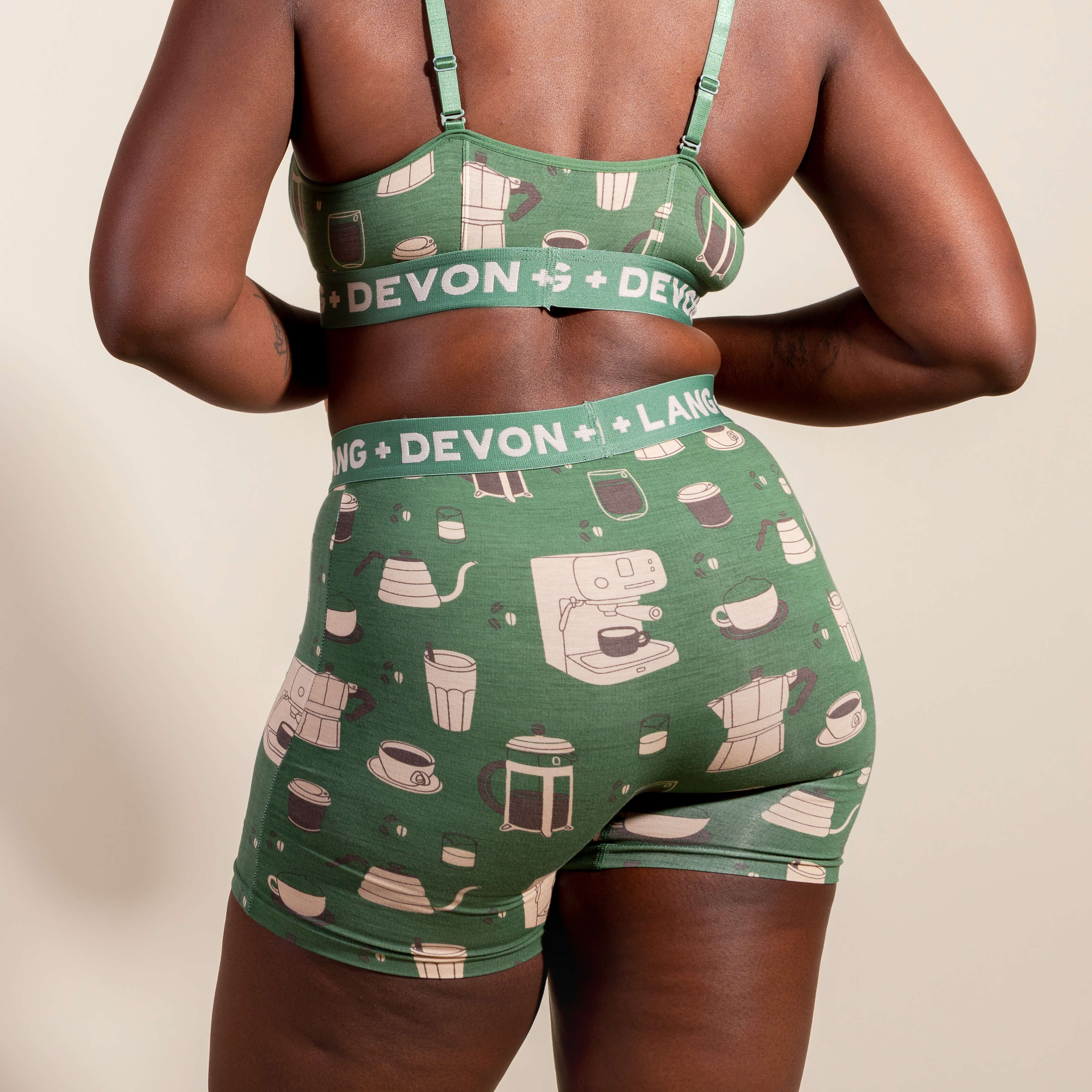 Green patterned bralette and shorts set with 'Devon + Lang' branding on a beige background