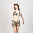 Woman wearing a patterned bralette and shorts set with ''Devon + Lang'' branding on a plain background