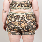 Person wearing a floral patterned underwear set with 'Devon + Lang' branding on a plain background