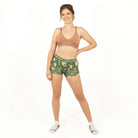 Woman wearing a green patterned underwear set on a white background