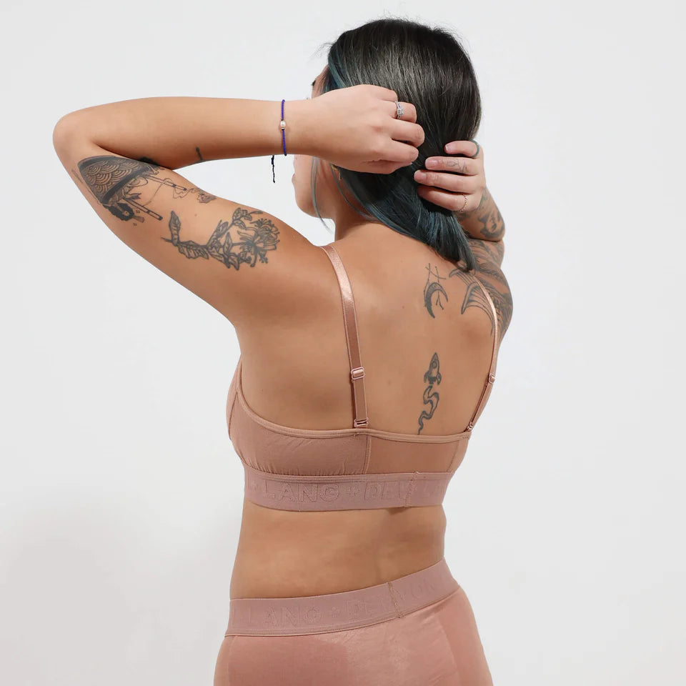 A woman wearing a brown bra on a white background