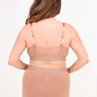 A woman wearing a brown bra and shorts set on a white background