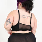 A woman wearing a black bra and shorts set on a white background