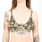 Woman wearing a floral-patterned bralette with visible branding on a white background