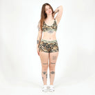 Woman wearing a floral sports bra and shorts set on a white background