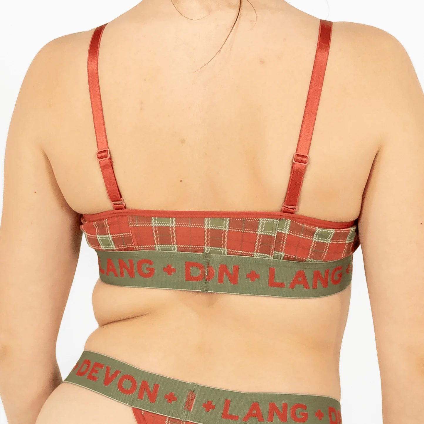 Green and red plaid bra and underwear set with visible branding on a plain background
