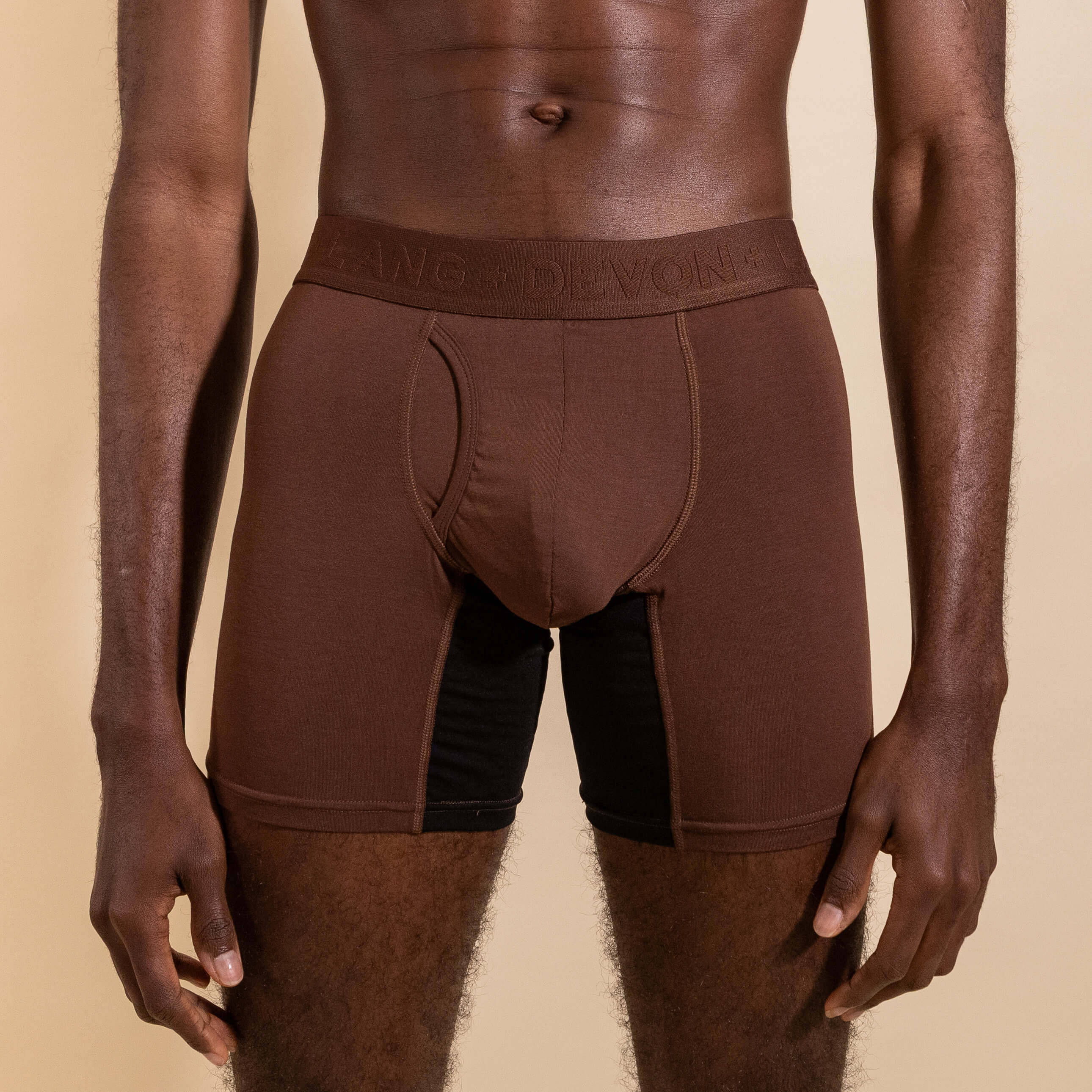 Brown boxer briefs worn by a person on a beige background