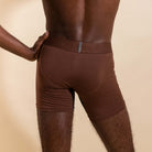 Brown boxer briefs with a brand logo on a beige background