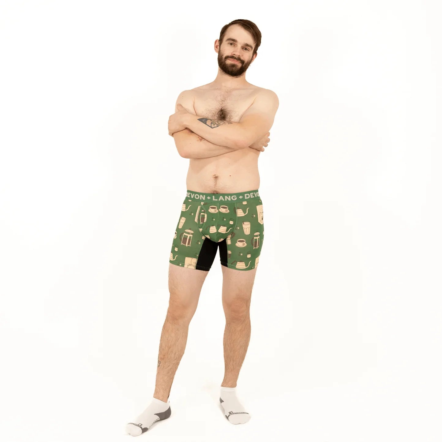 Man wearing green patterned boxer briefs on a white background