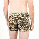 A man wearing floral boxer brief underwear with visible branding against a white background