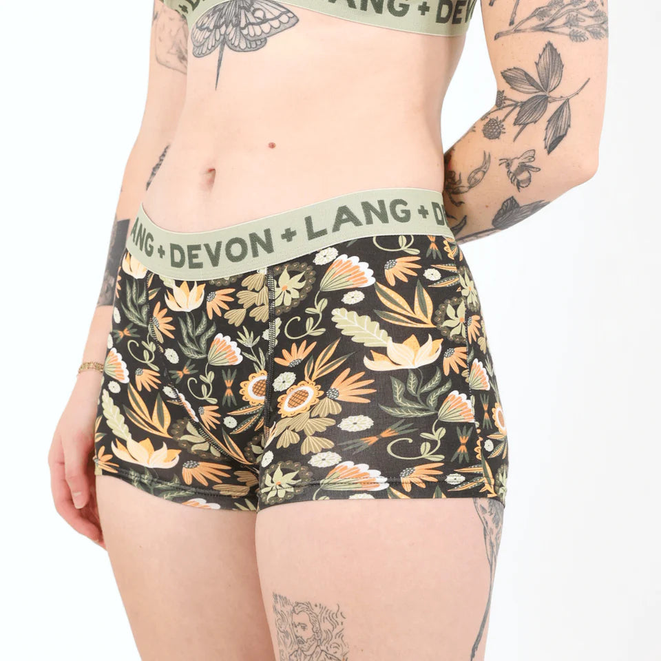 A woman wearing a floral boyshort against a white background