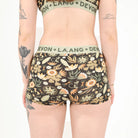 A person wearing floral boyshort underwear against a white background