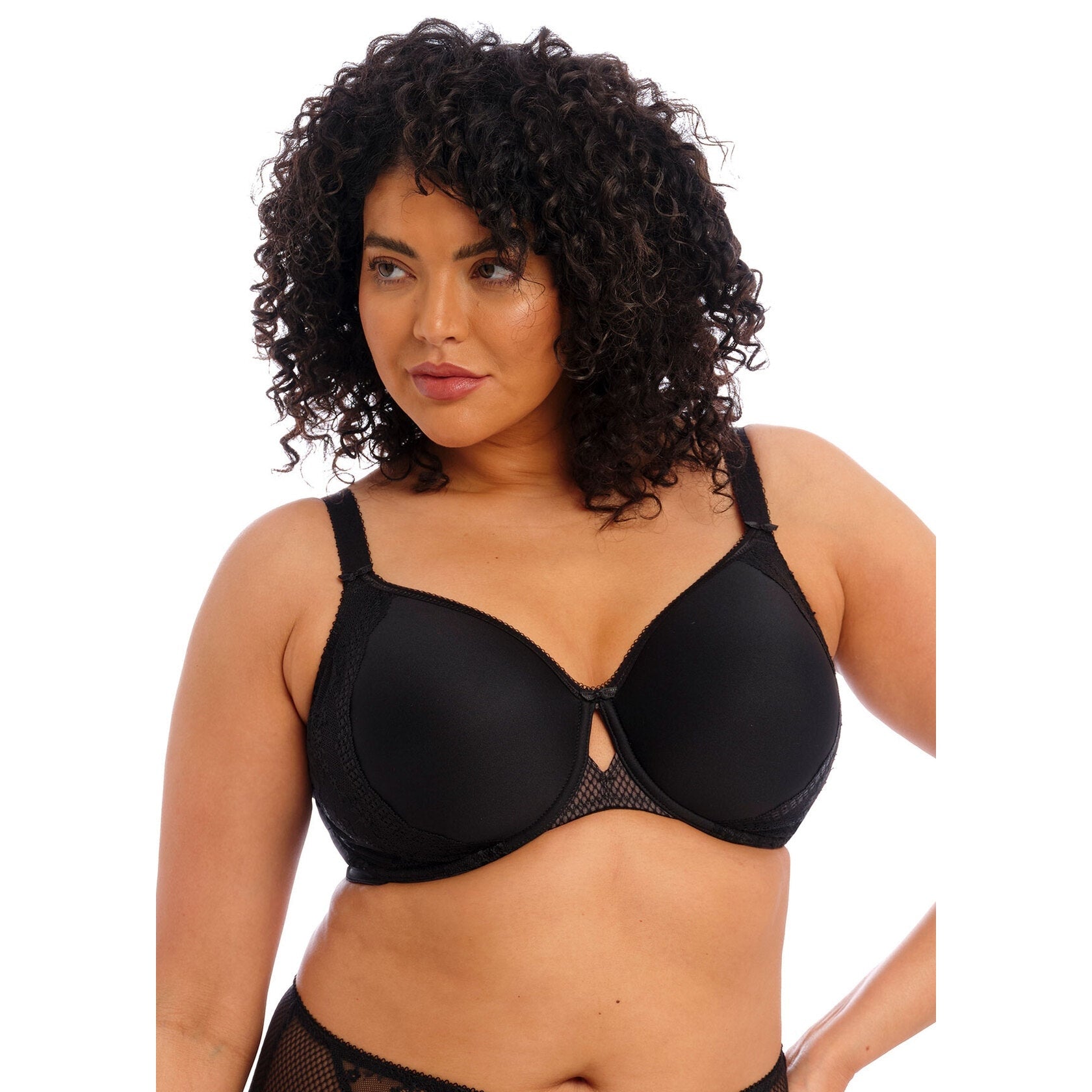 Woman wearing a black moulded bra with lace details against a white back ground. 