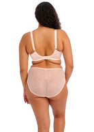 Woman wearing a blush pink bra and underwear set on a white background