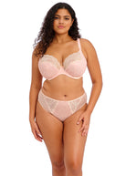 Woman wearing a pink lace lingerie set on a white background