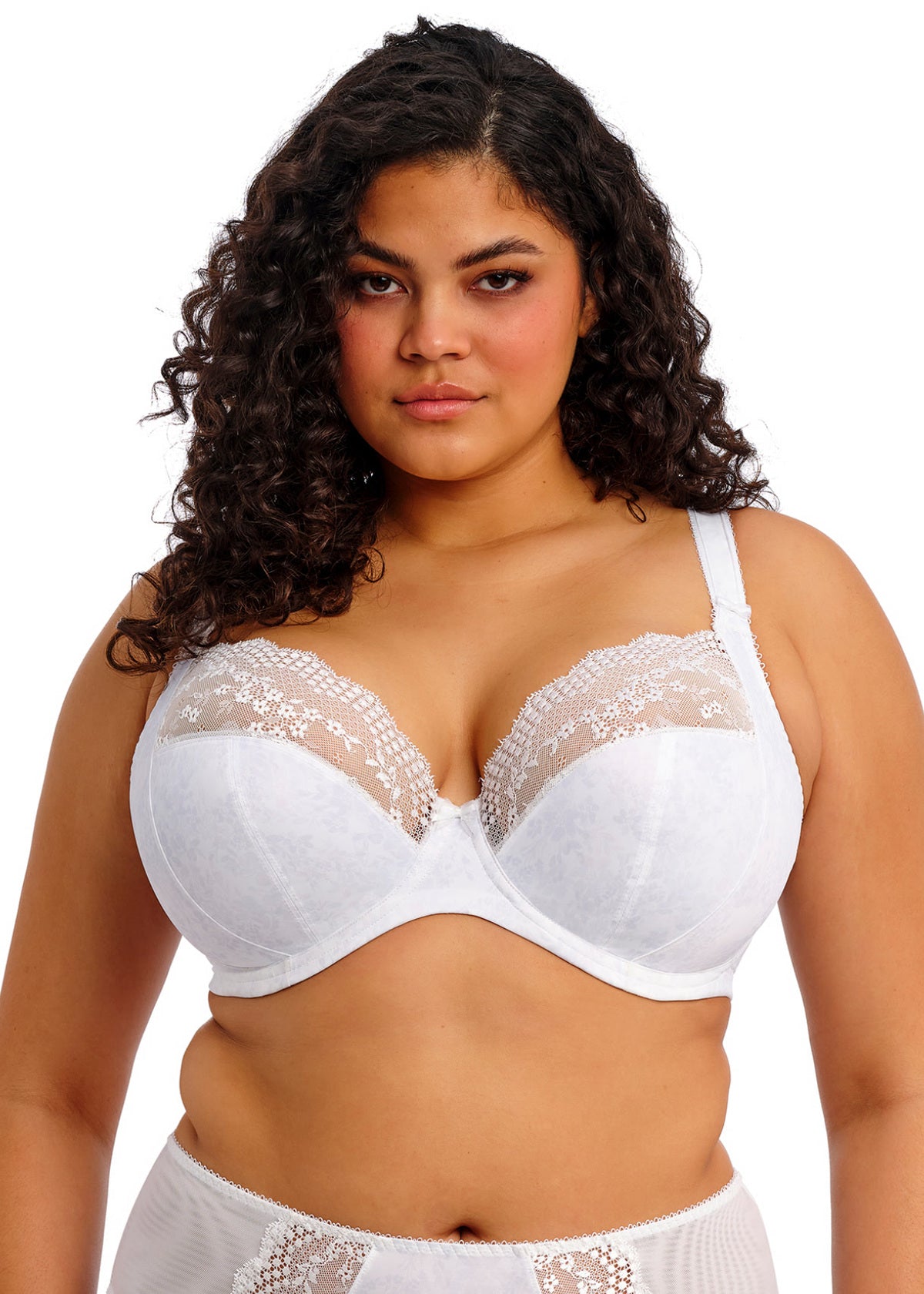 Woman wearing a white lace bra and panties set on a white background