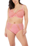 Woman wearing a pink bra and high-waisted panties set on a white background