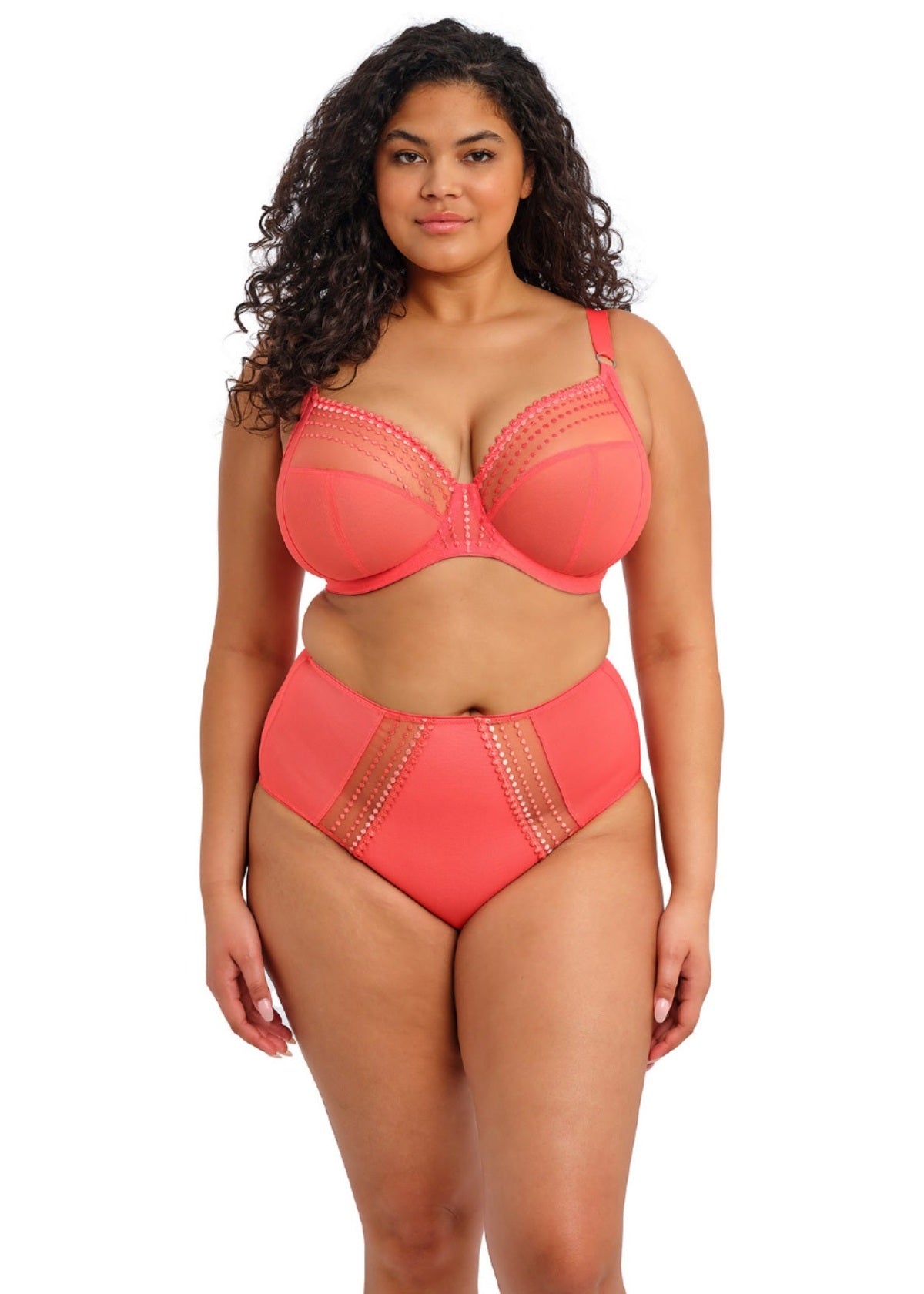 Woman wearing a coral bra and panty set on a white background