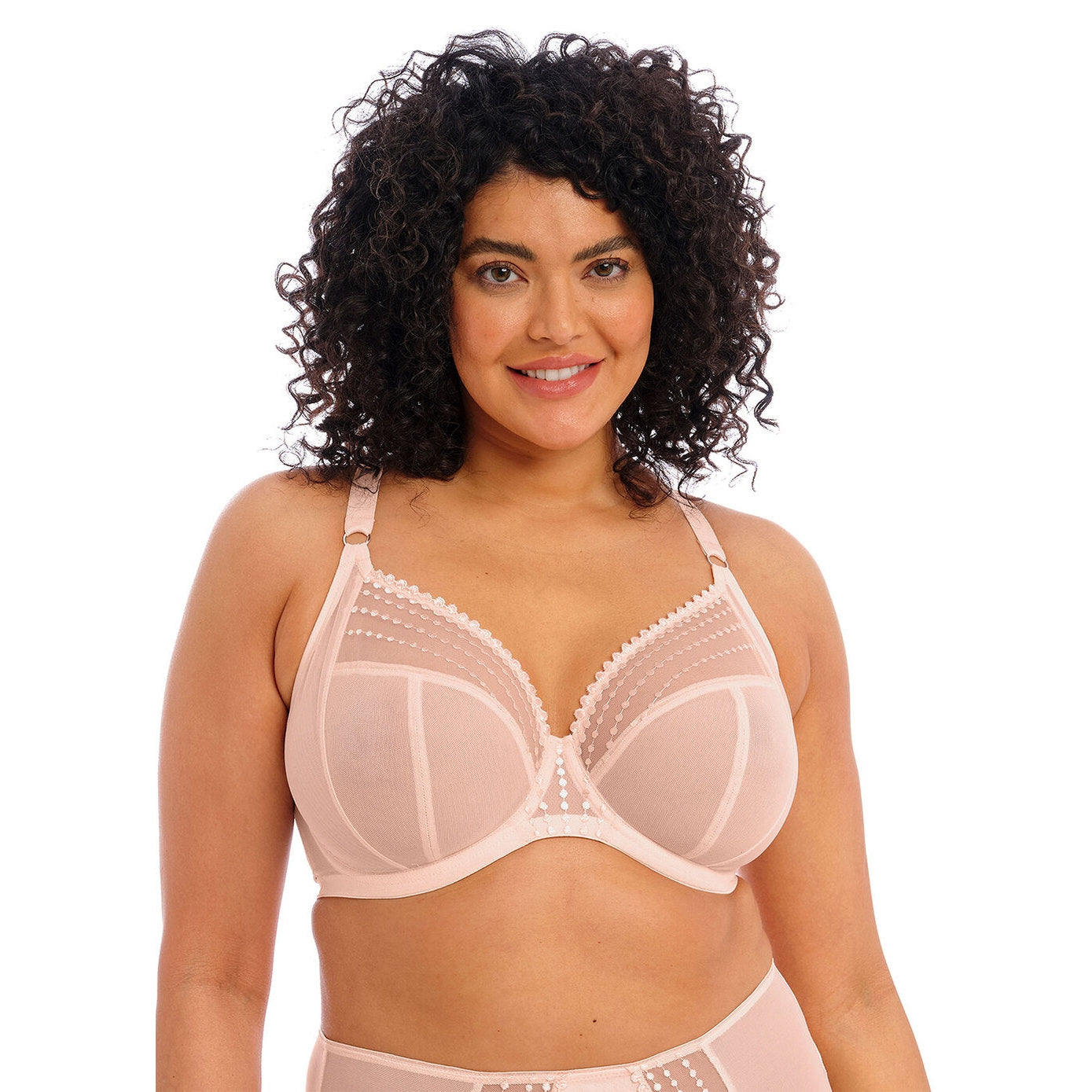 A woman is wearing a beige plunge bra with contemporary bead embroidery. The bra has three-piece cups and side support panels, featuring an elasticated neck edge and moveable J-hook fastening.