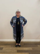 Person wearing a patterned outfit standing in a room with wooden flooring.