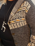 Close-up of a textured garment with patterned trim and buttons.