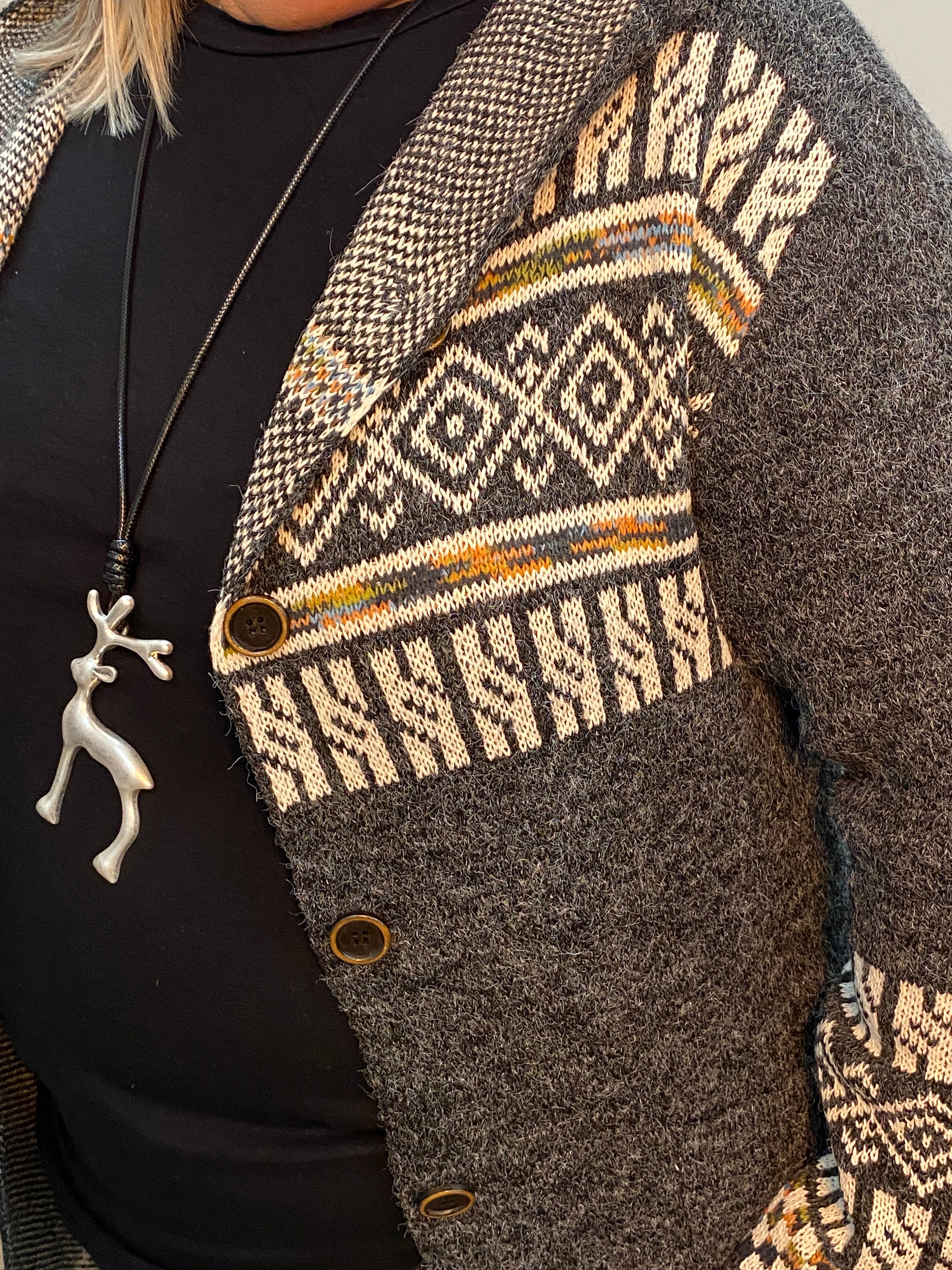 Close-up of a textured garment with patterned trim and buttons.