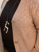 Close-up of a grey textured sweater with buttons and a black belt with a decorative buckle.