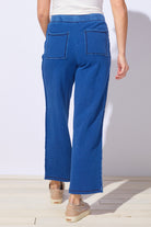 Person wearing blue jeans on a plain background