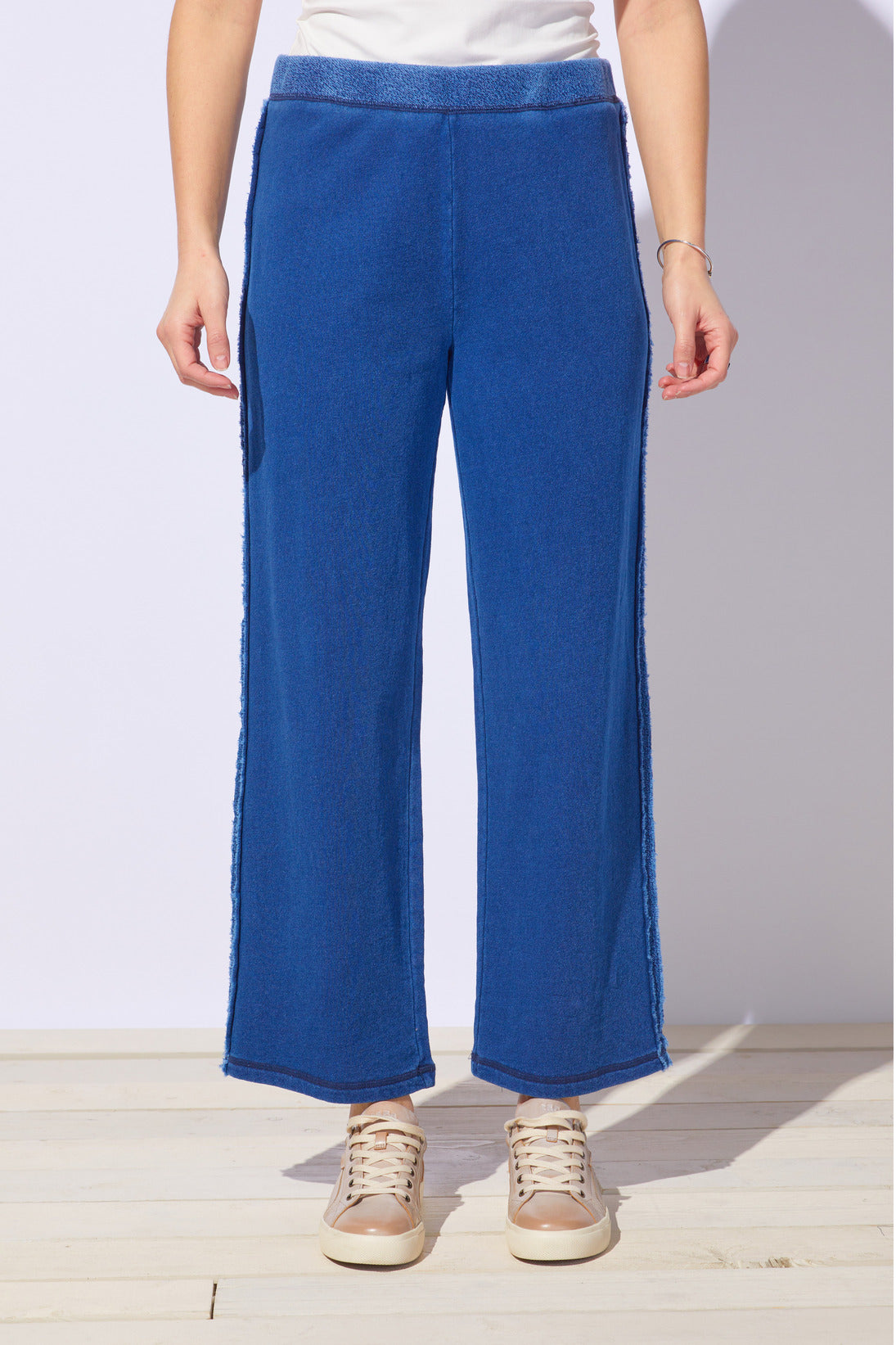 Person wearing blue pants with a white background