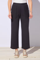 Person wearing black wide-leg pants with a plain background