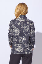 Person wearing a floral patterned jacket on a plain background