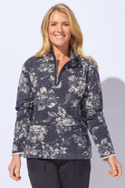 Woman wearing a patterned navy jacket against a light gray background