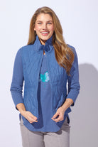 Woman wearing a blue quilted jacket with a white background